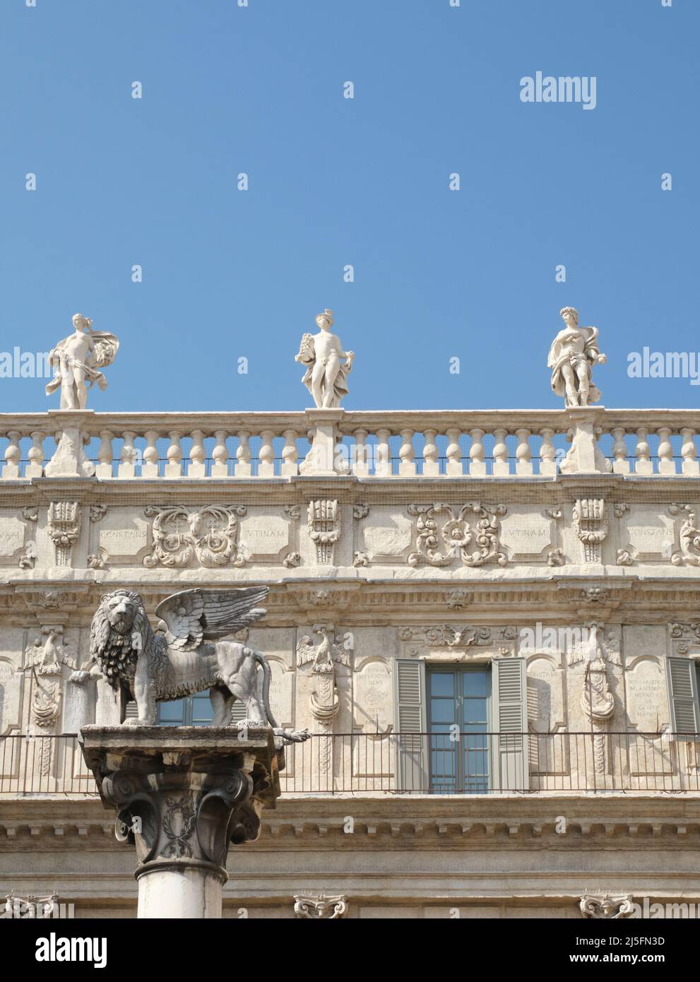 Traditional symbol of the Venetian Empire, a winged lion with a book, sculpted and standing in front of an elaborate building. Stock Photo
