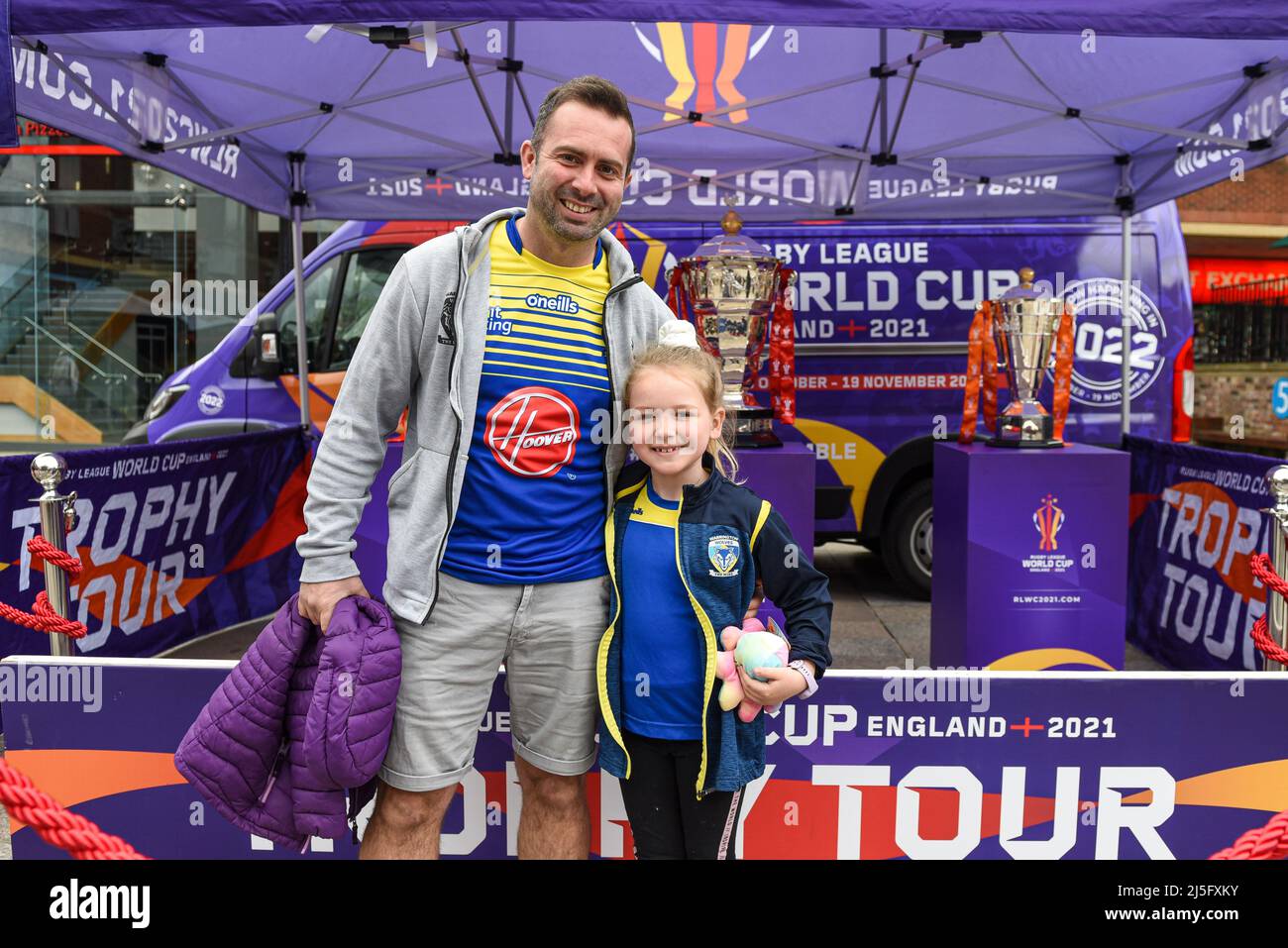 Some Warrington Wolves fans pose for photos next to the Rugby League World Cup Trophies in the fan zone before the game Stock Photo