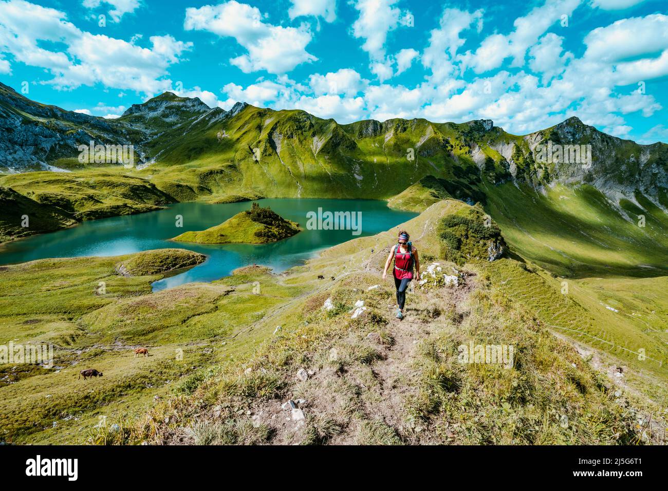 Woman is hiking around lake Schrecksee in the bavarian alps Stock Photo