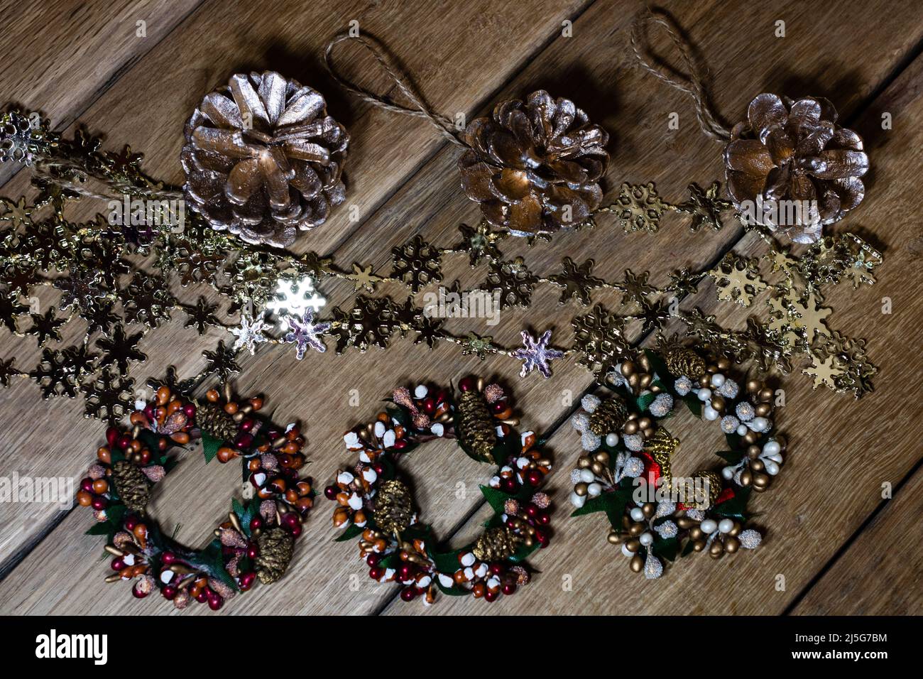 Christmas decorations on wooden board. Christmas pine cones and wreaths ...