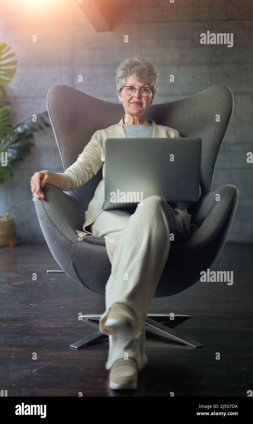woman sitting on modern chair near the window in light cozy room at