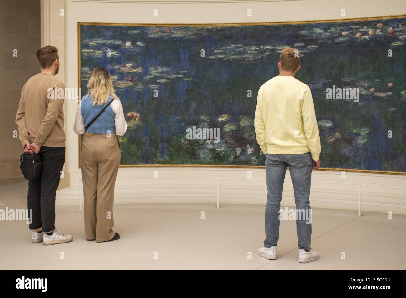 Paris, France, Europe: visitors in front the Nympheas (Water Lilies), famous series of decorative panels by Claude Monet at the Musee de l'Orangerie Stock Photo