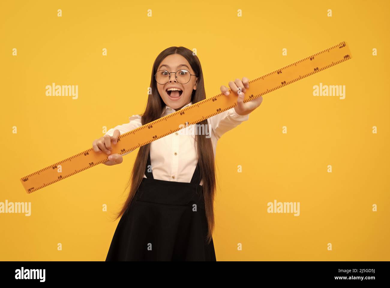 amazed teen girl in school uniform and glasses hold mathematics ruler ...
