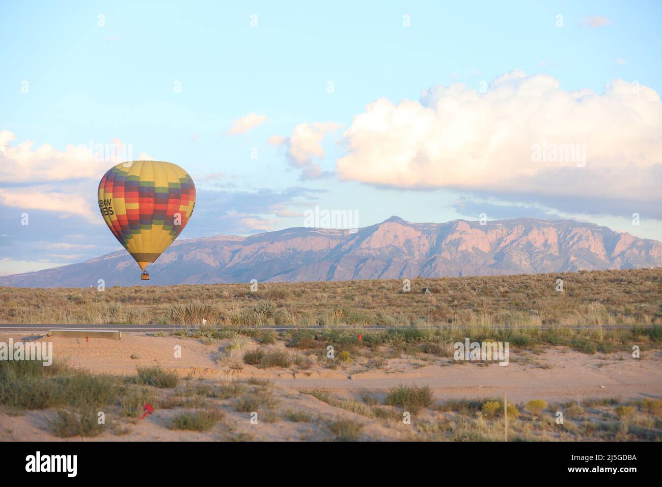 Hot air balloon moving with Sandia Hills in the background in New Mexico Stock Photo