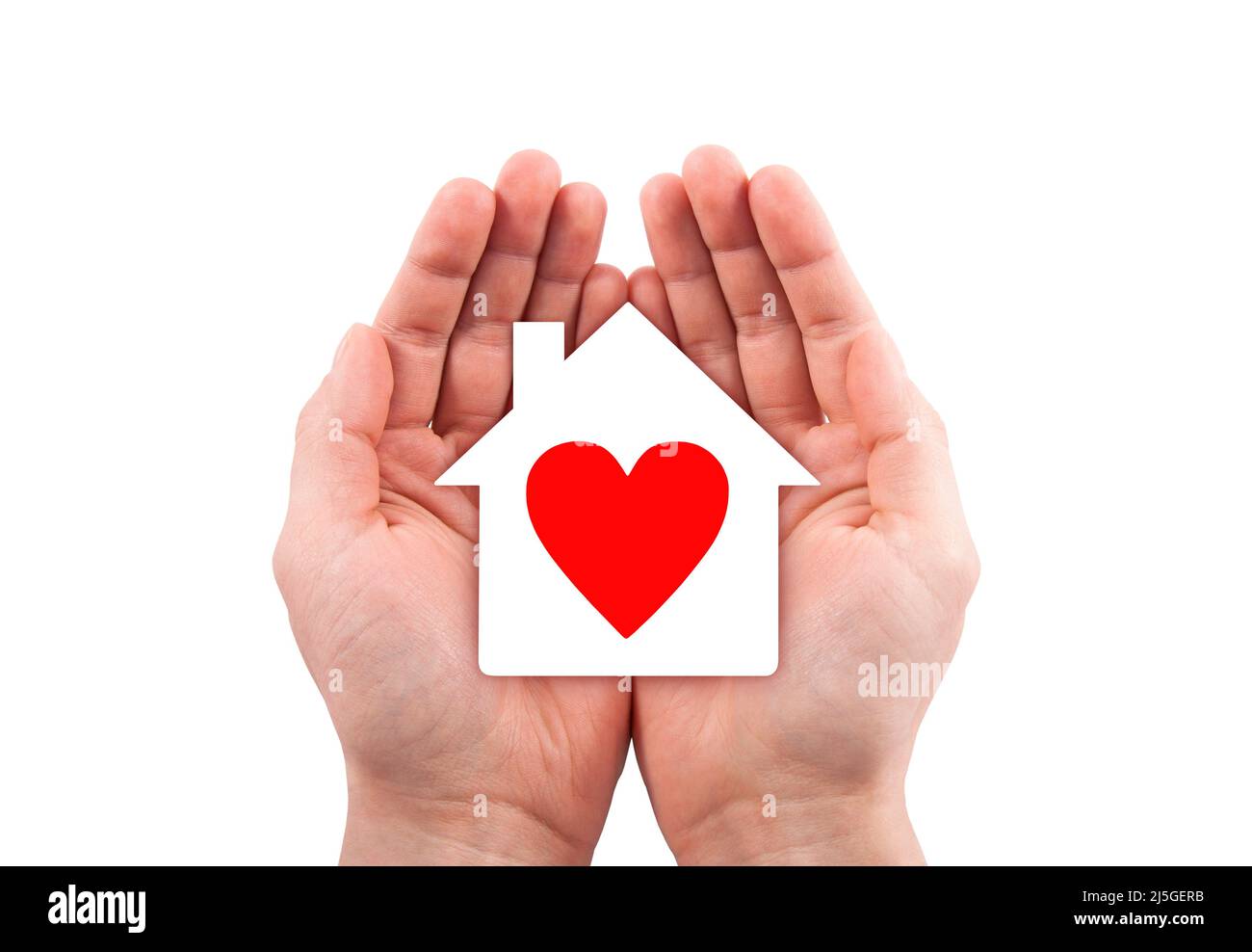 Paper house with red heart cutout in hands isolated on white background with clipping path. Stock Photo