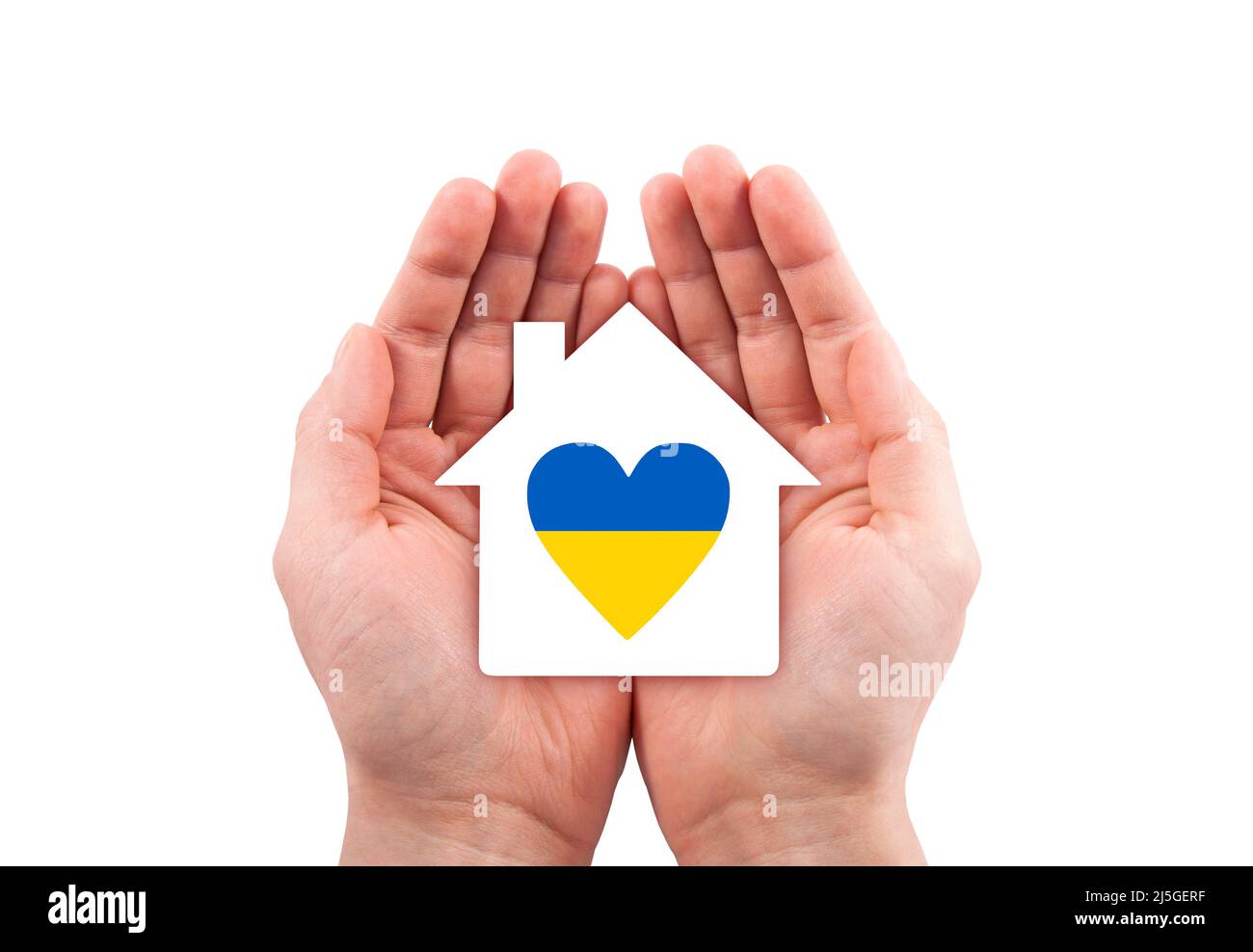 Paper house with Ukrainian heart cutout in hands isolated on white background with clipping path. Stock Photo