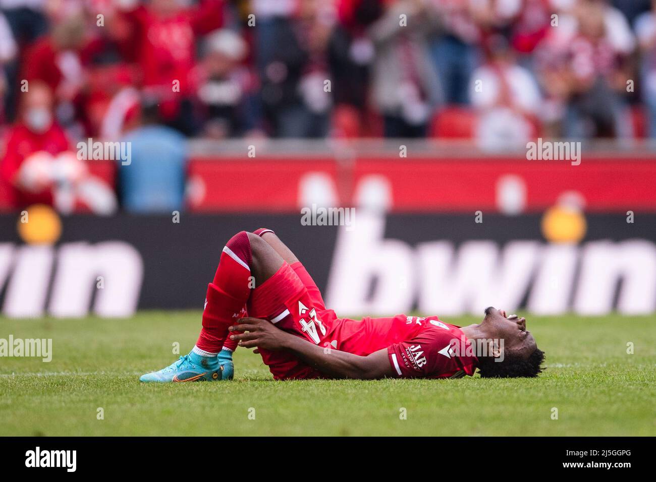 Cologne, Germany. 23rd Apr, 2022. Soccer: Bundesliga, 1. FC Köln - Arminia Bielefeld, Matchday 31, RheinEnergieStadion. Bielefeld's George Bello lies on the ground after the match. Credit: Marius Becker/dpa - IMPORTANT NOTE: In accordance with the requirements of the DFL Deutsche Fußball Liga and the DFB Deutscher Fußball-Bund, it is prohibited to use or have used photographs taken in the stadium and/or of the match in the form of sequence pictures and/or video-like photo series./dpa/Alamy Live News Stock Photo