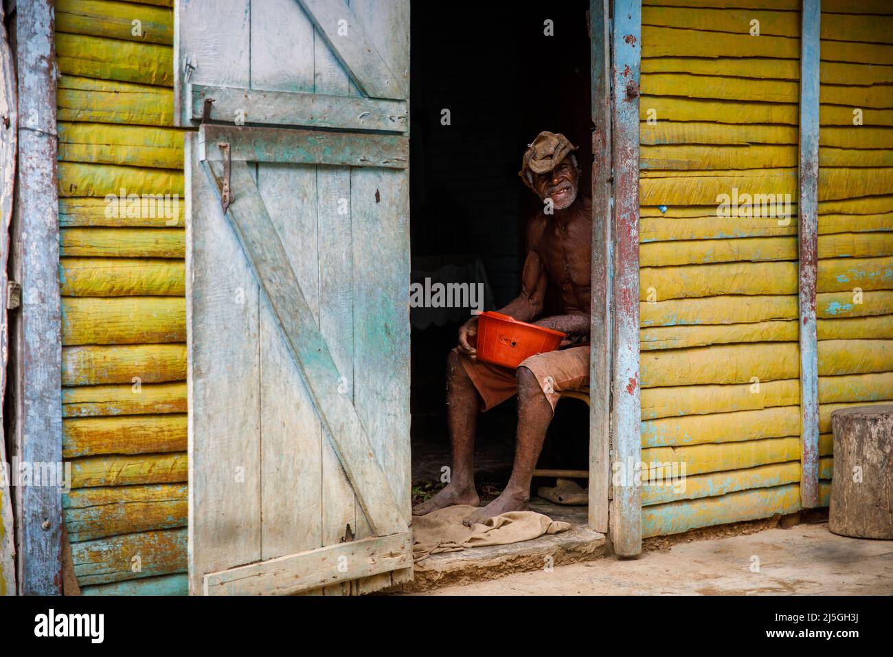 2022.19.03 Dominican Republic provinces La Altagracia. An elderly Haitian man is sitting near his house. Portrait of an elderly man. Stock Photo