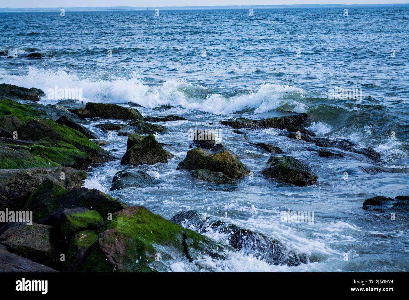 Waves splashing on the stones at the beach Stock Photo - Alamy