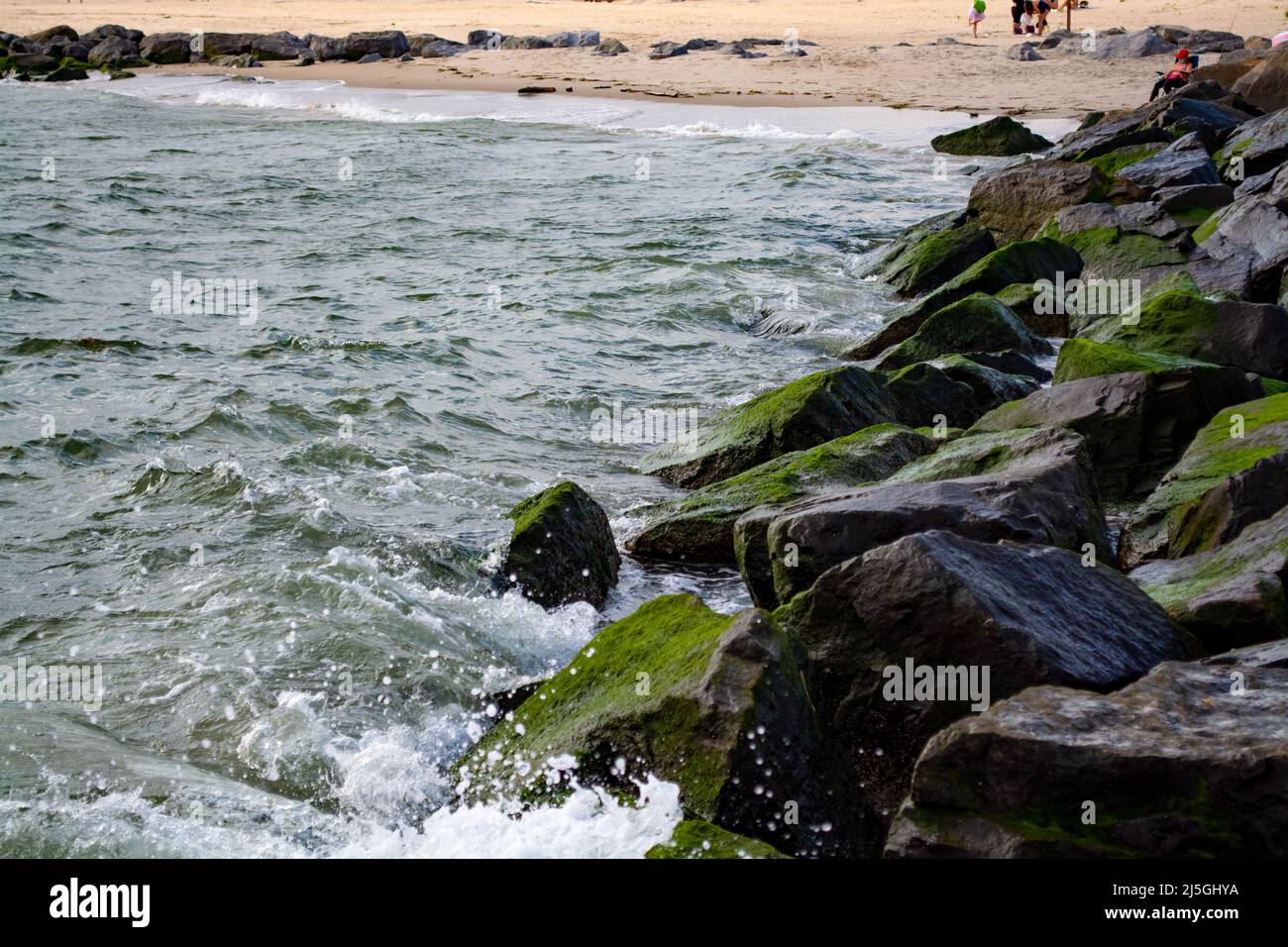 Waves splashing on the stones at the beach Stock Photo - Alamy