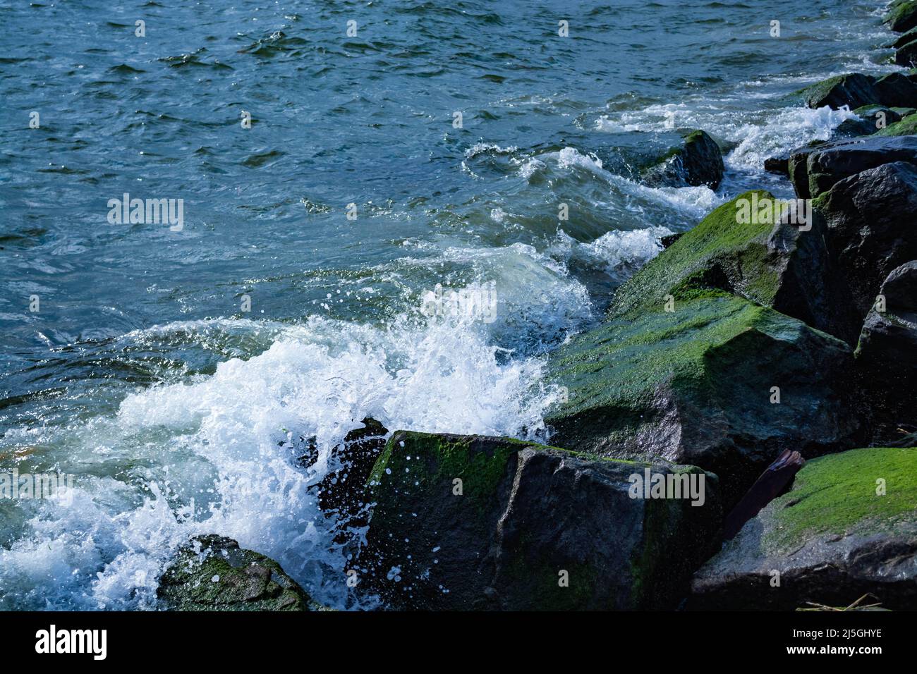 Waves splashing on the stones at the beach Stock Photo - Alamy