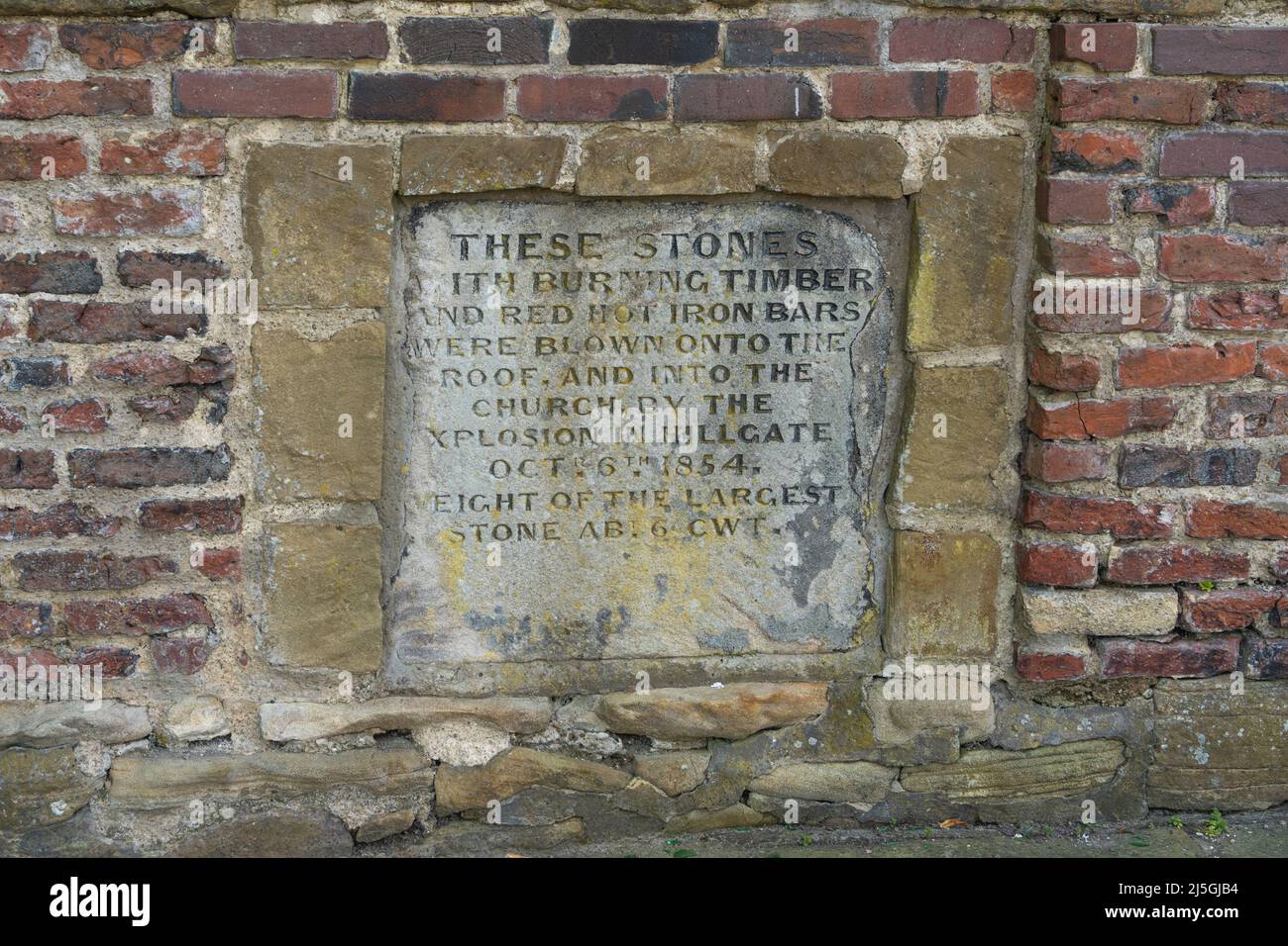 Stones in the wall outside St Mary's, Gateshead, UK, that were propelled onto the church by an explosion and telling story of the Great Fire of 1854. Stock Photo