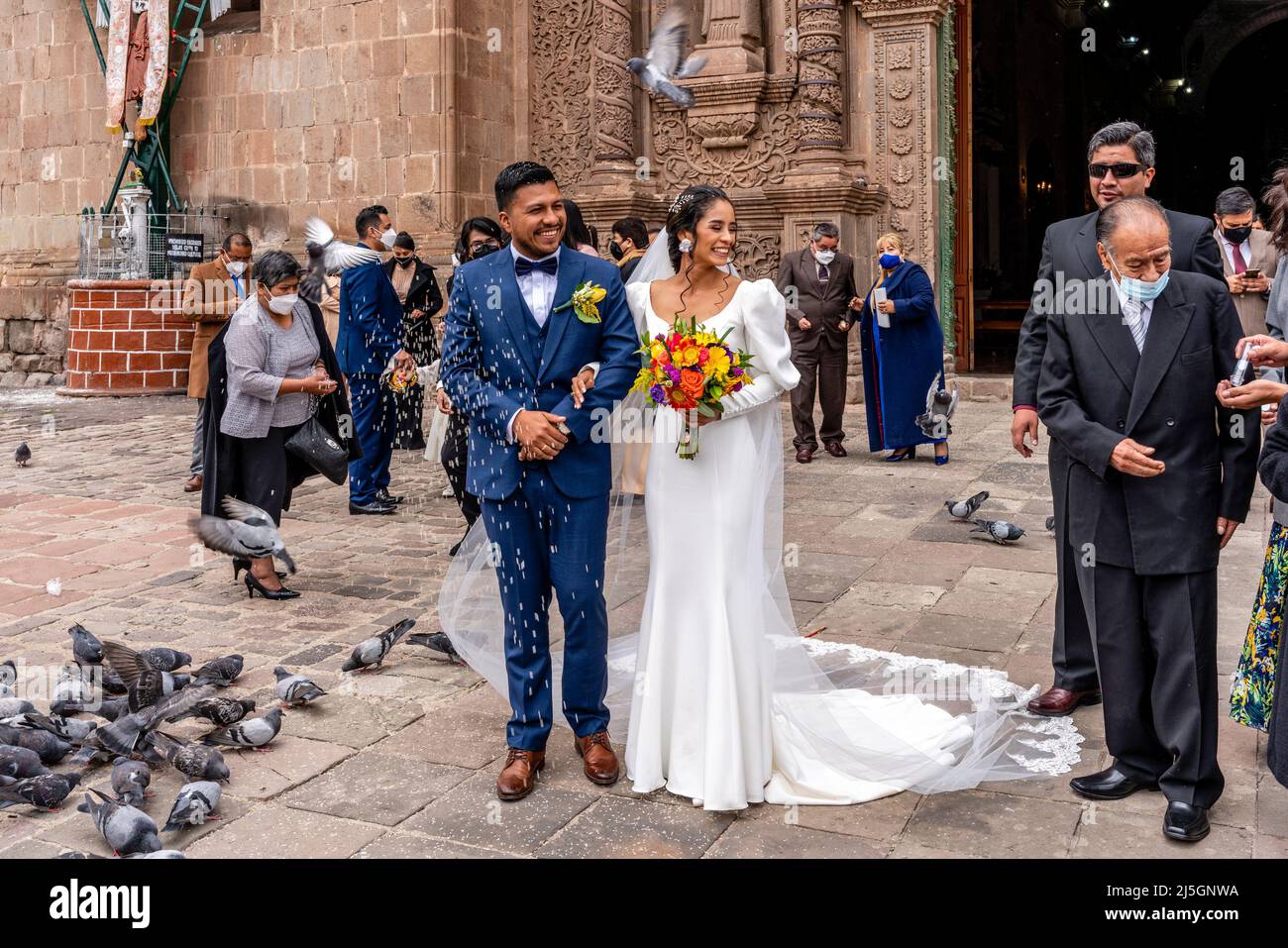 A Young Peruvian Couple Leave The Cathedral After Getting Married, The Plaza de Armas, Puno, Peru. Stock Photo