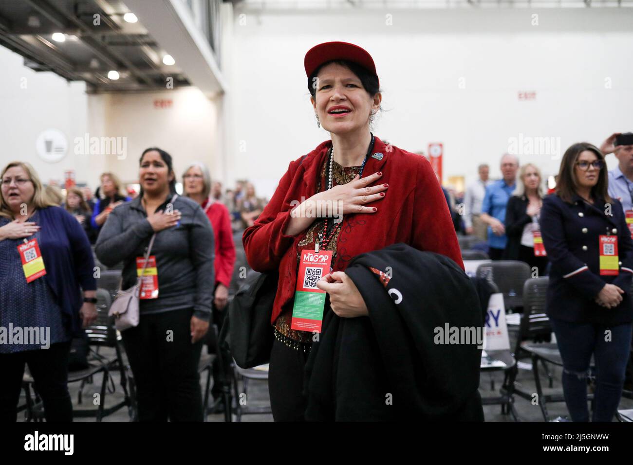 Christina Hickson, delegate for the 8th district in Genesee County holds her hand over her heart as she recites the national anthem during the "Empowering Michigan 2022" Michigan GOP members convention at DeVos Place in Grand Rapids, Michigan, U.S., April 23, 2022.  REUTERS/Emily Elconin Stock Photo