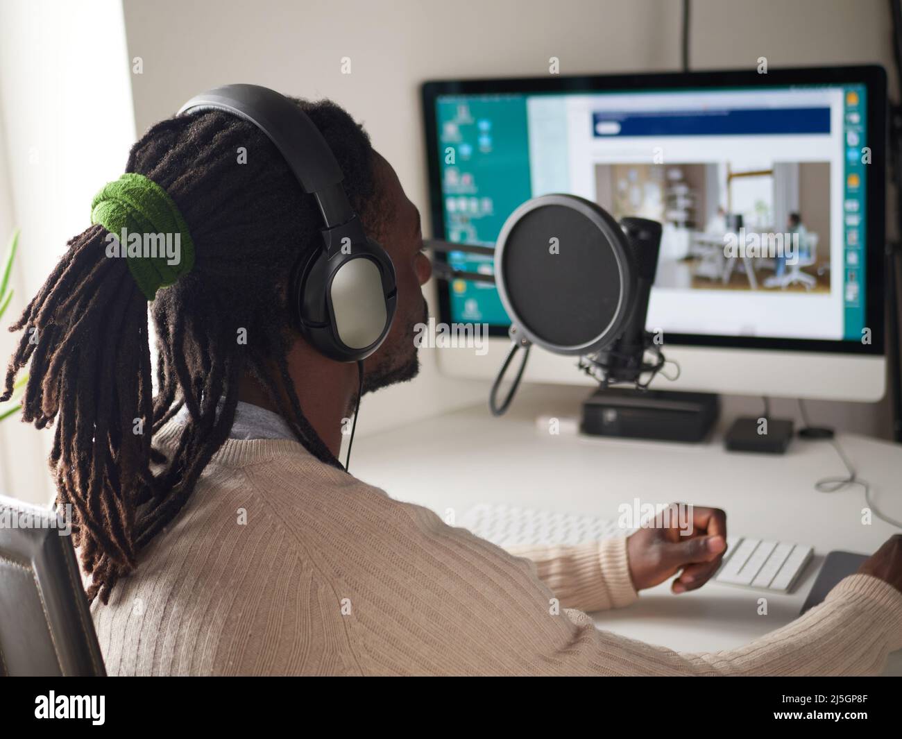 afroamerican  happy young male recording audio blog in headphones microphone broadcasting at home ... Stock Photo