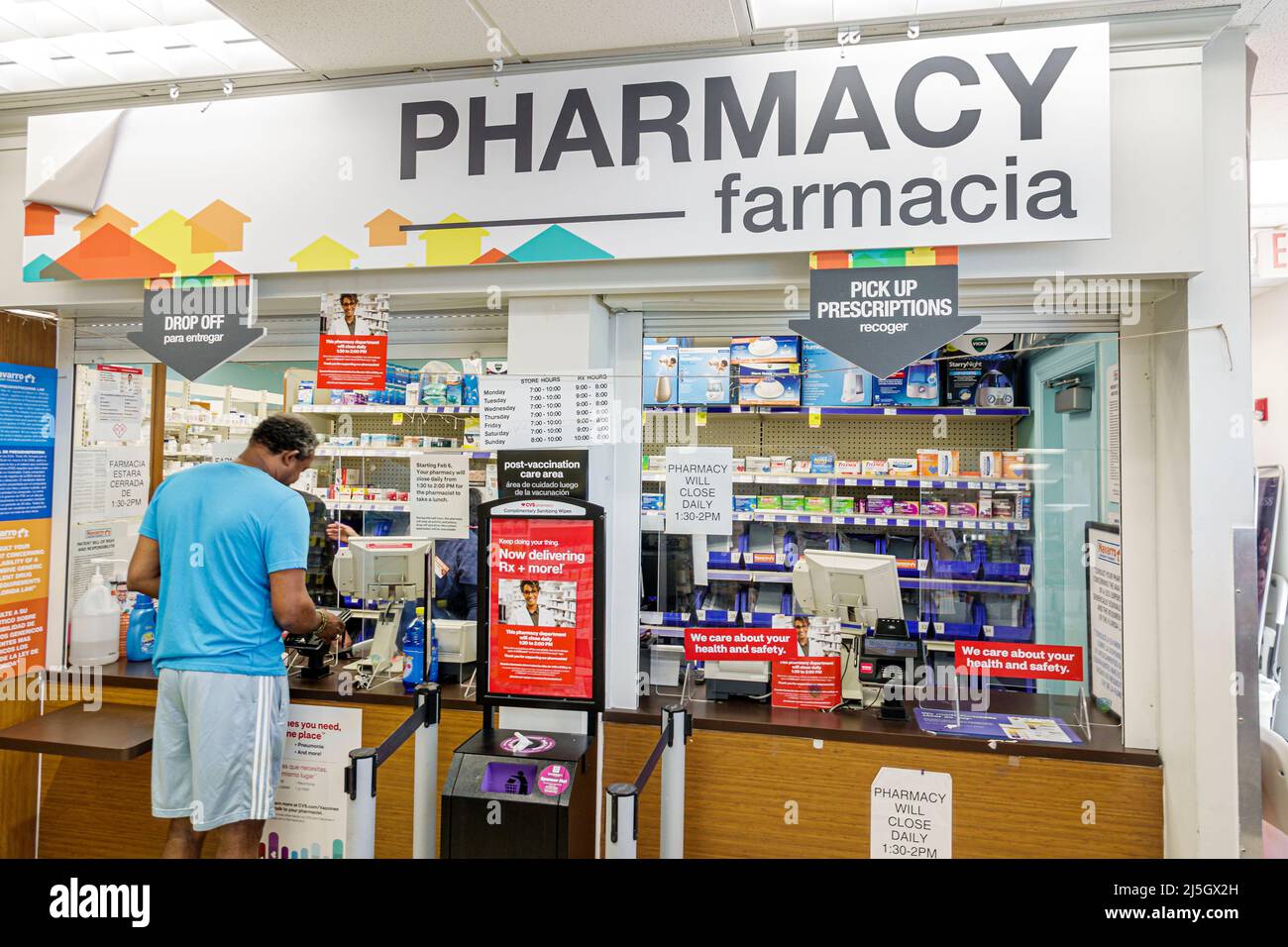 Miami Beach Florida Navarro Pharmacy drugstore inside interior counter Spanish English bilingual language languages Black man male customer Stock Photo