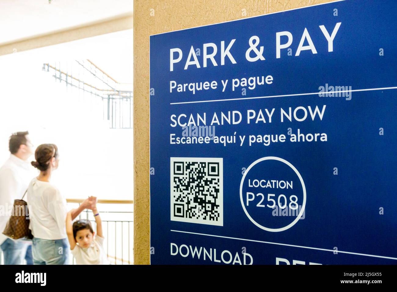 Miami Florida Coral Gables Shops at Merrick Park upscale outdoor shopping mall car park parking garage sign scan pay now QR code Hispanic family Spani Stock Photo