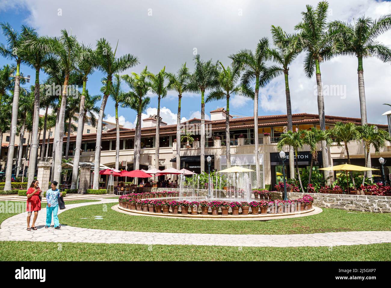 Miami Florida Coral Gables Shops at Merrick Park upscale outdoor shopping mall fountain women friends walking talking Stock Photo