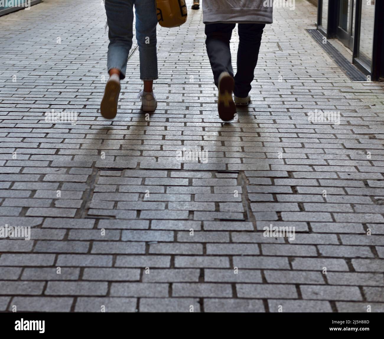 Legs of two people walking away Stock Photo