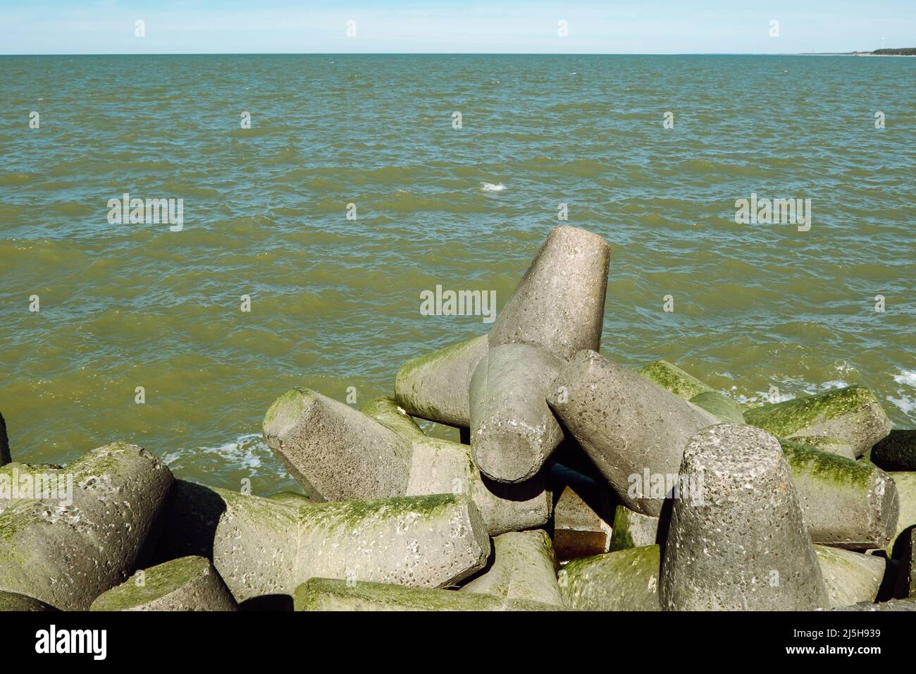 The Northern Breakwater in Liepaja, a close-up of tetrapods and splashing, splattering waves. Dolosse structure in the Baltic sea Stock Photo