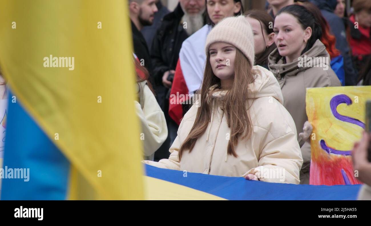 Girl on the background of a yellow-blue flag at a rally in support of Ukraine Stock Photo