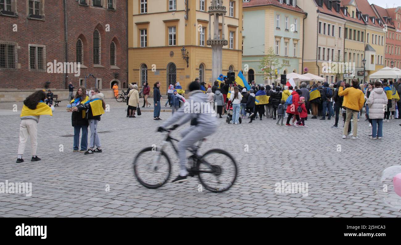 Cyclist passing by a rally of refugees in support of Ukraine Stock Photo