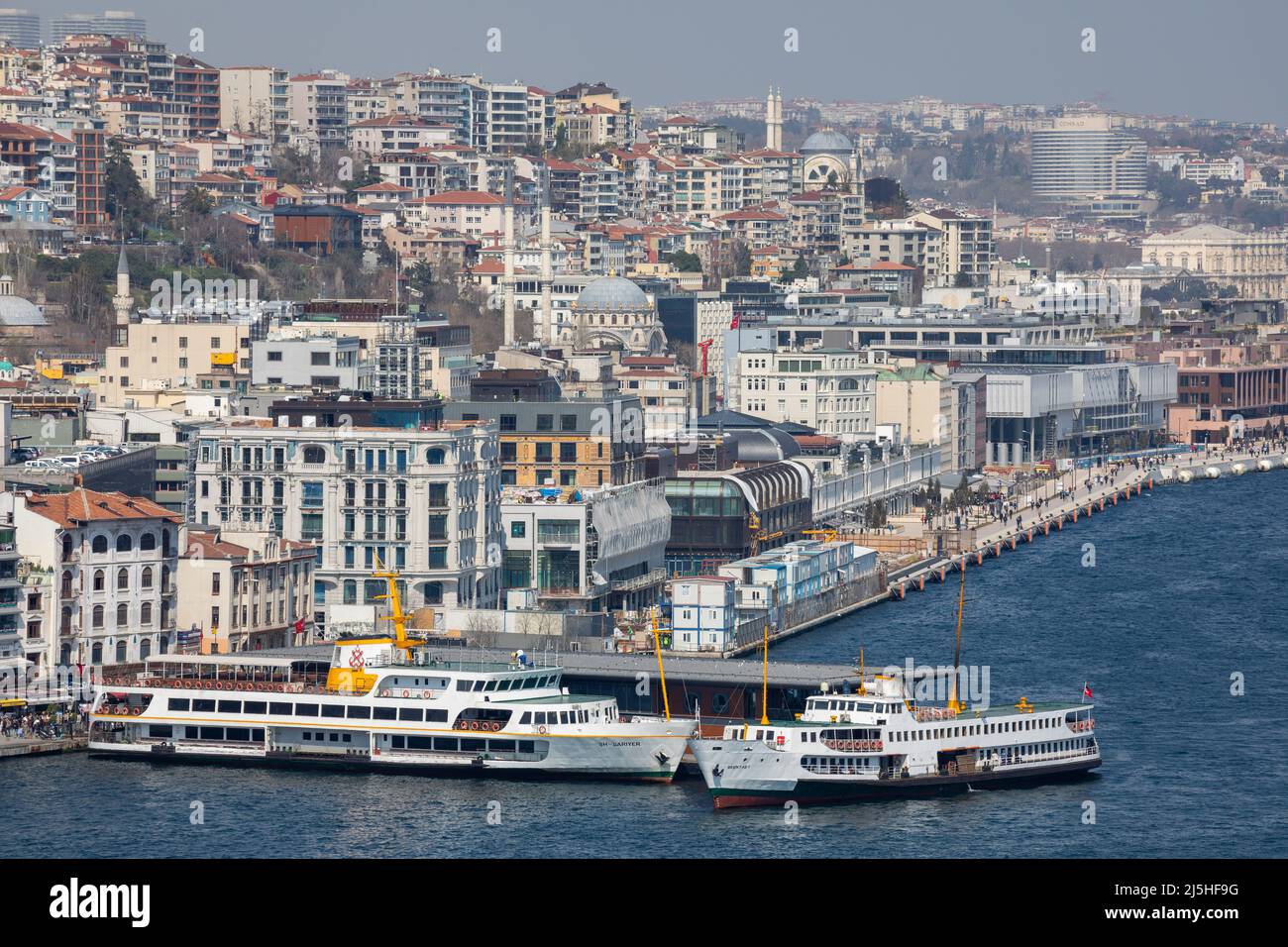 High angle zoomed view of Istanbul City Lines Ferry disembarking passengers at Karakoy pier on the Golden Horn with Galataport and Karakoy background. Stock Photo