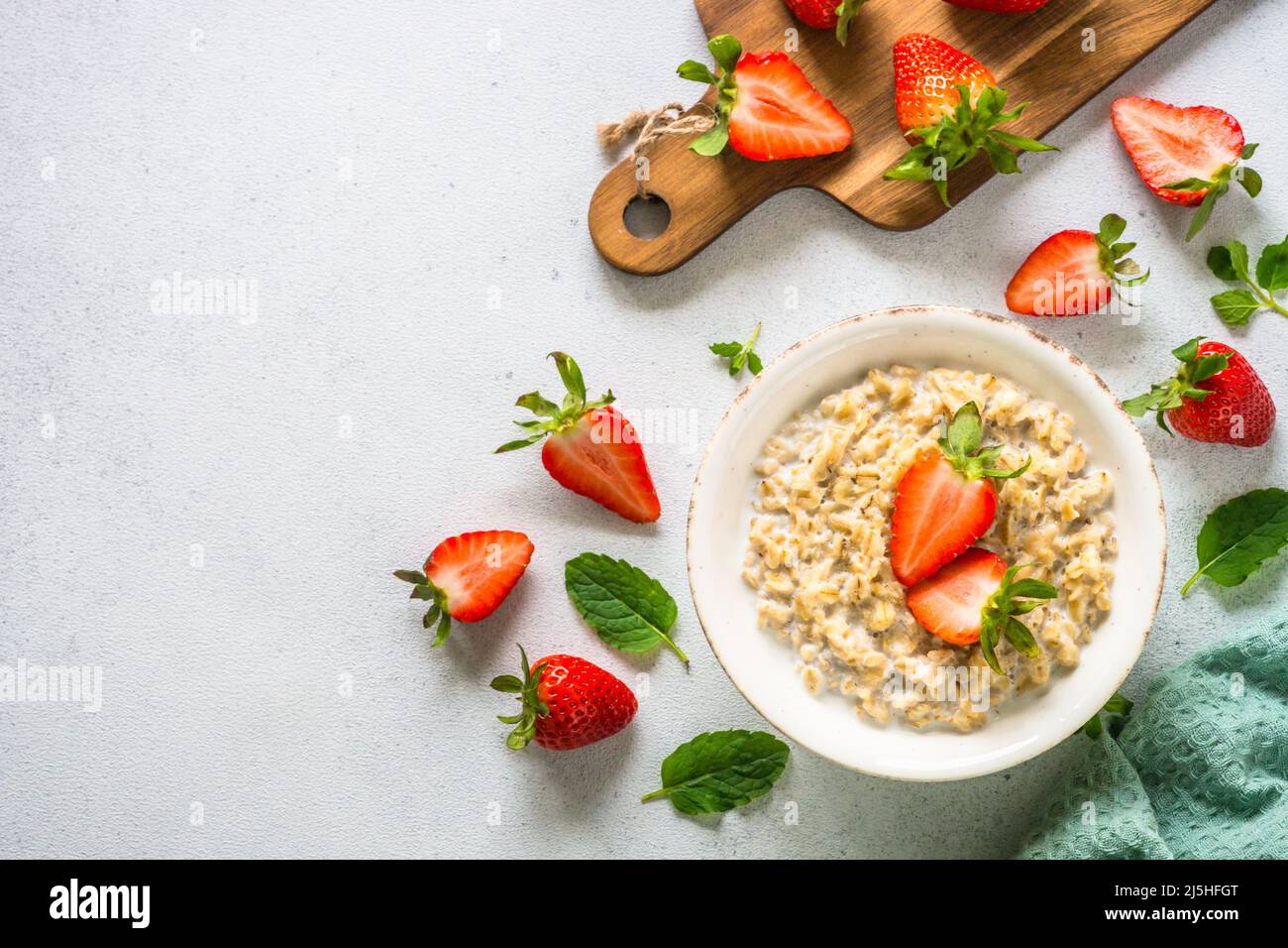 Oatmeal porridge with strawberry on white background. Stock Photo