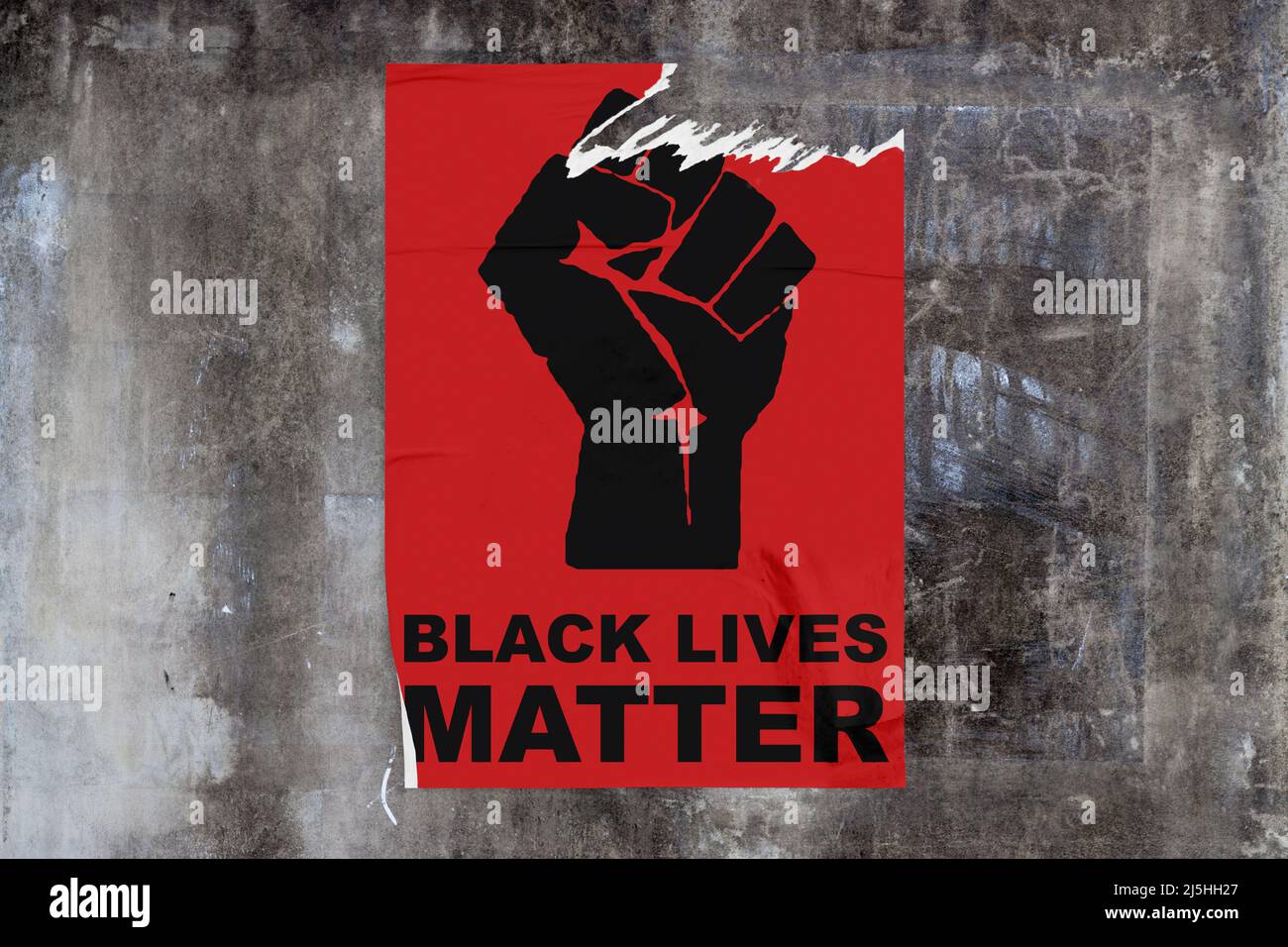 Full-frame weathered concrete wall with a torn red poster in the middle dispicting a black fist with 'Black lives matter' written bellow. Stock Photo