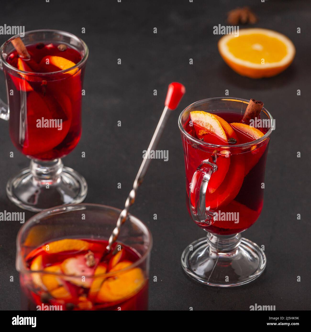 Alcoholic mulled wine with fruits and spices on a dark background