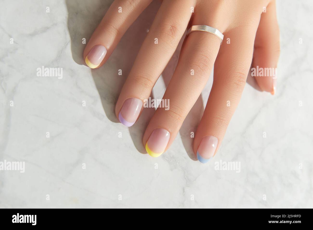 Beautiful womans hand with spring summer nail design on marble gray  background Stock Photo - Alamy