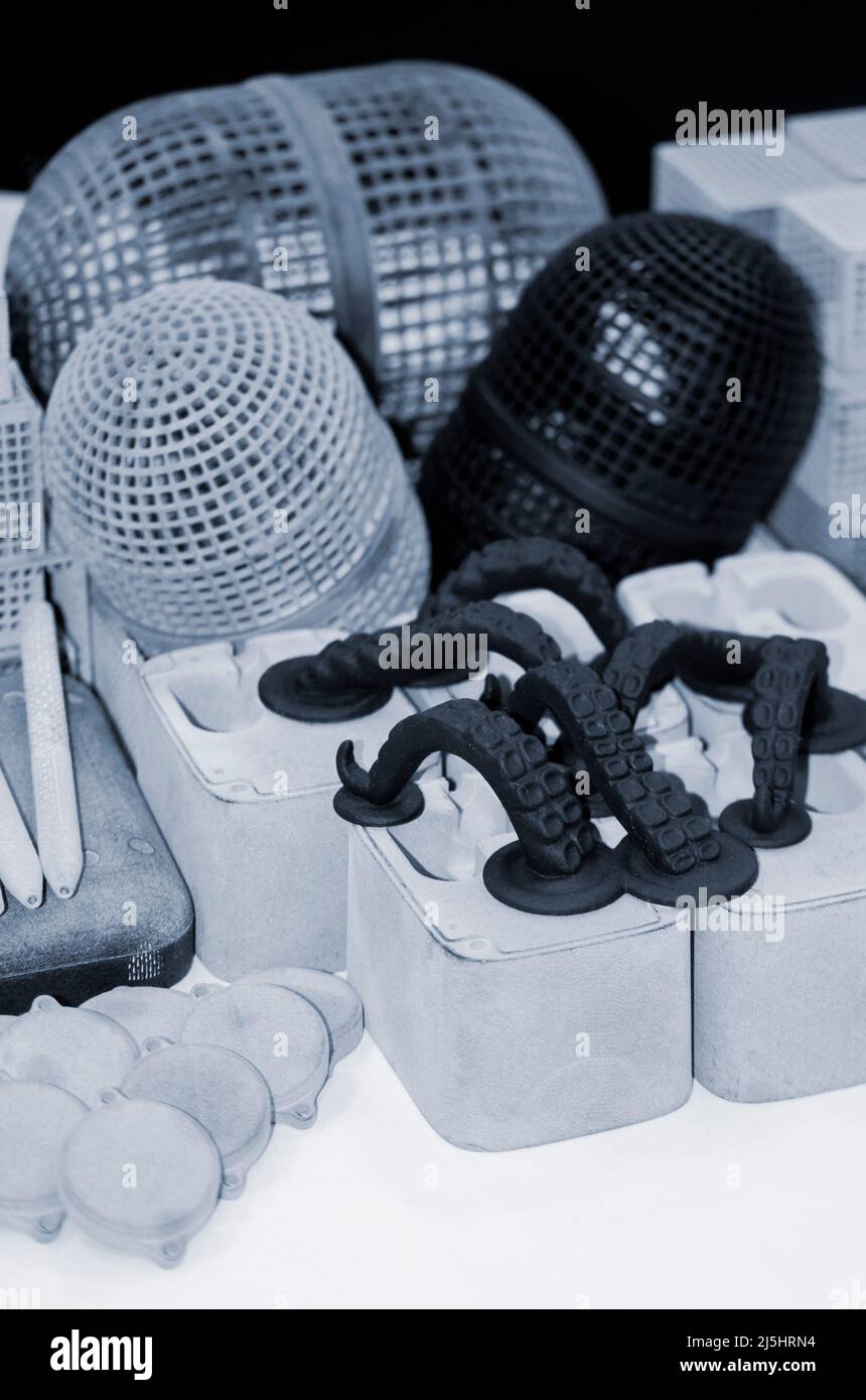 Many different models printed on 3D printer. Gray and black objects printed Stock Photo