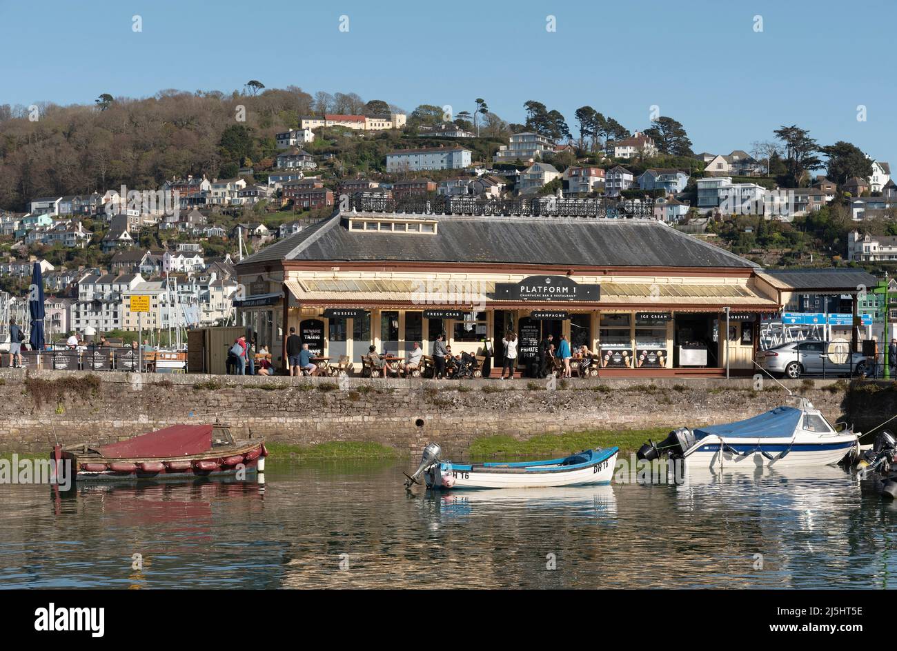 Dartmouth South Devon, England, UK. 2022. Historic booking office and station now a cafe restaurant seen accross Dartmouth Harbour. Stock Photo
