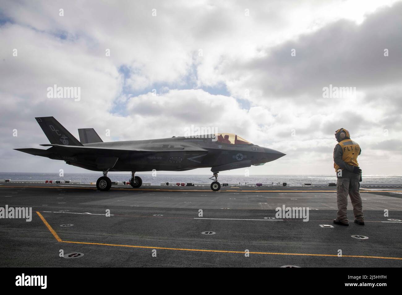 220411-N-IV962-2171    PACIFIC OCEAN (April 11, 2022) – Chief Aviation Boatswain’s Mate (Handling) Yuriy Dyshkant directs an F-35B Lightning II, assigned to Marine Fighter Attack Squadron (VMFA) 12aboard amphibious assault ship USS Makin Island (LHD 8), April 11. Pilots perform deck landing qualifications to practice shipboard takeoffs and landings. Makin Island is a Wasp-class amphibious assault ship underway conducting routine operations in U.S. 3rd Fleet. (U.S. Navy photo by Mass Communication Specialist 3rd Class Nadia Lund) Stock Photo