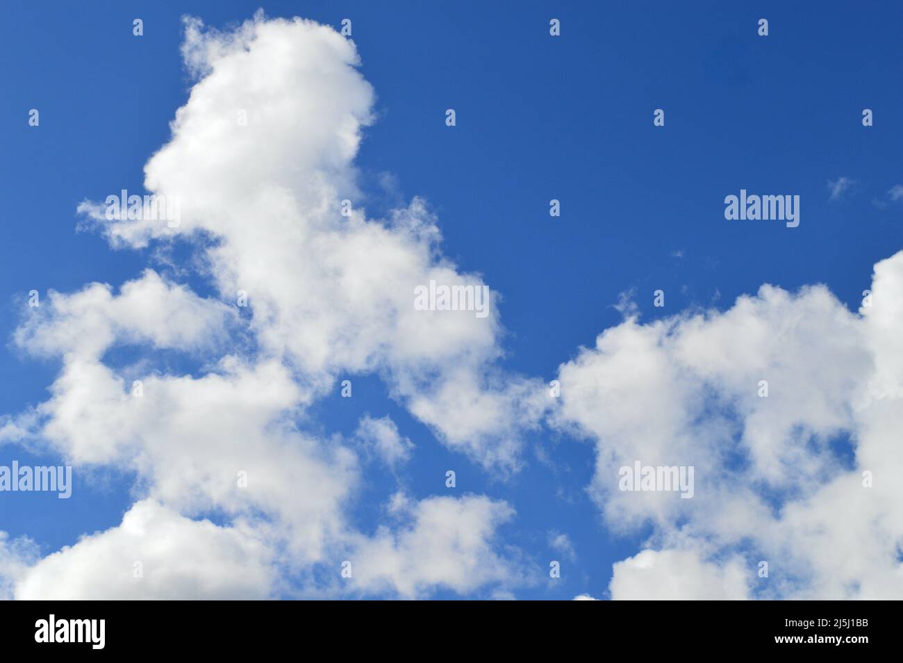 White clouds floating in a bright blue sky Stock Photo - Alamy