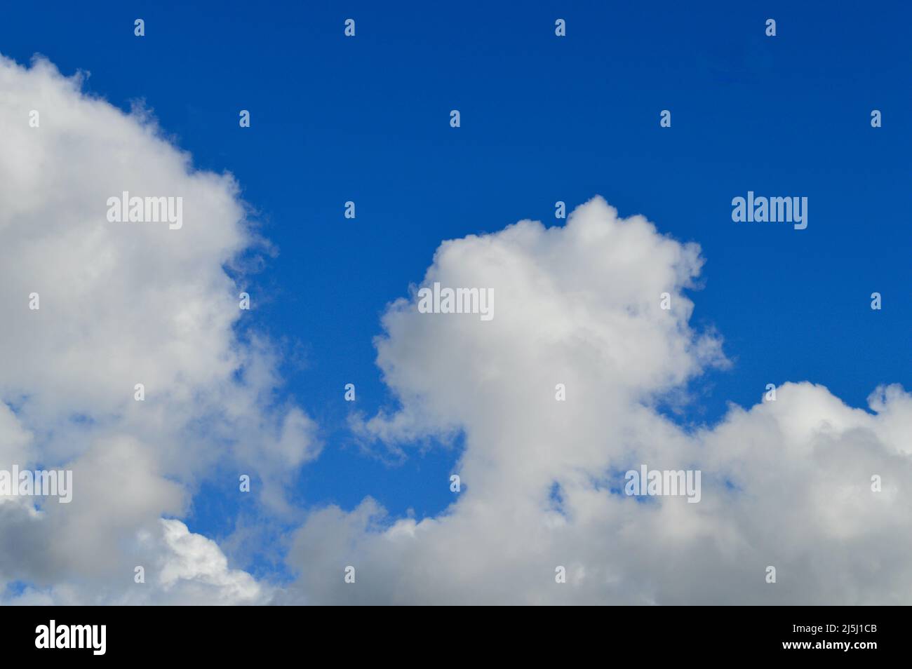 White clouds floating in a bright blue sky Stock Photo - Alamy