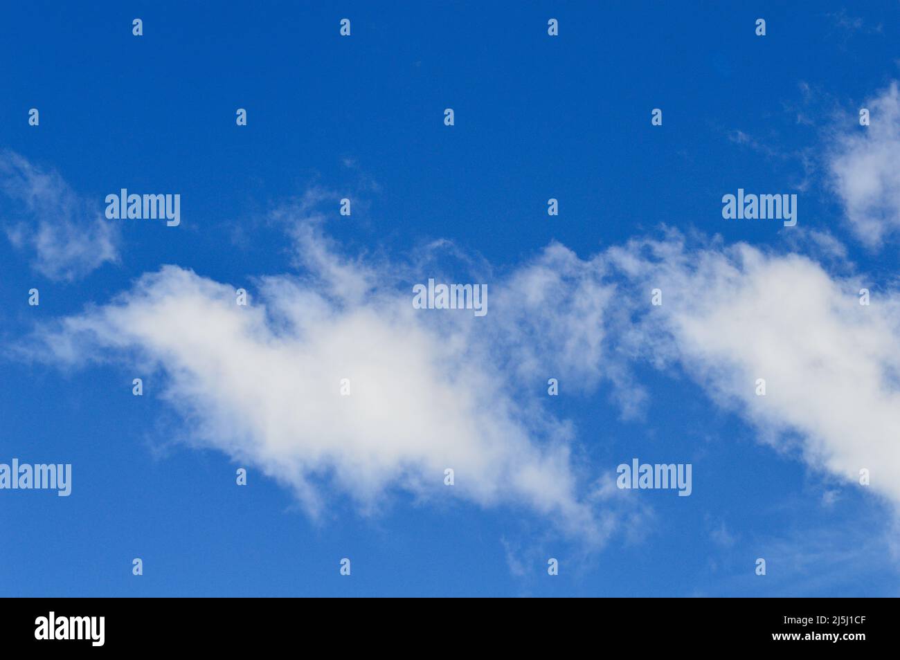 White clouds floating in a bright blue sky Stock Photo