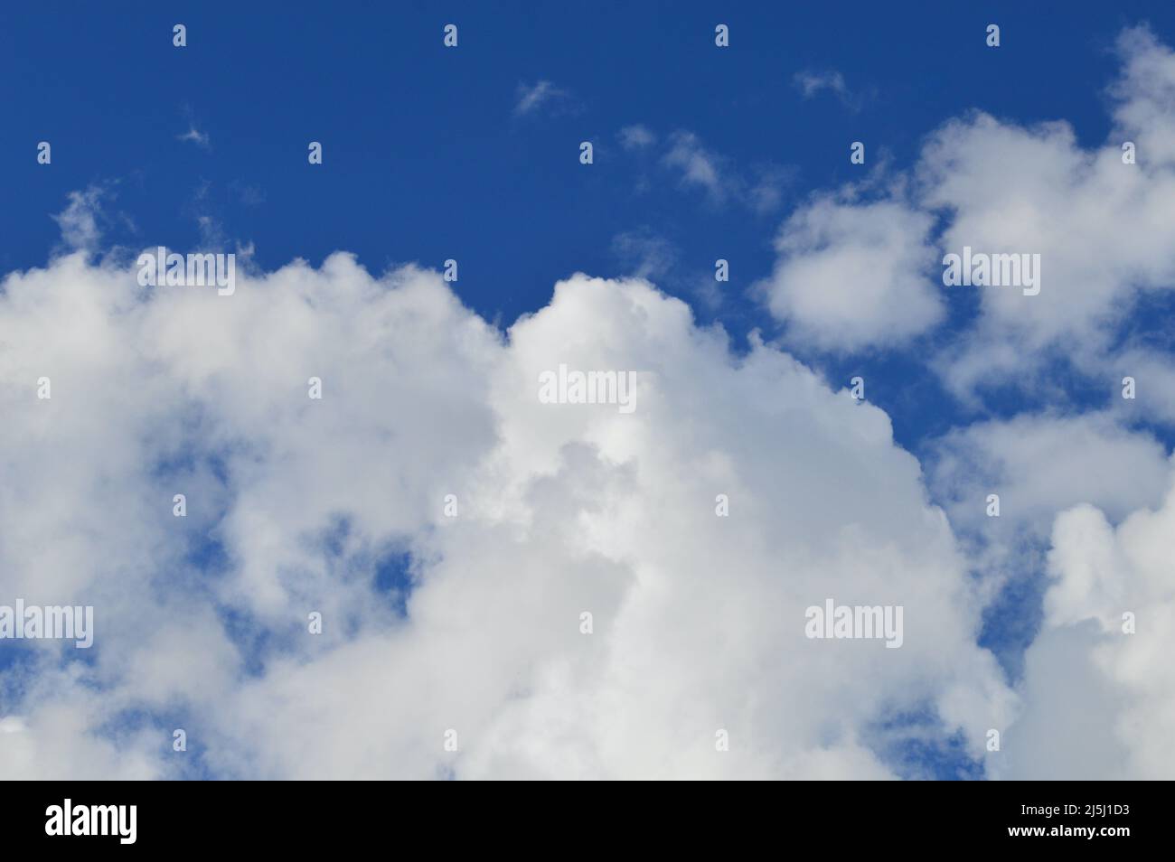 White clouds floating in a bright blue sky Stock Photo - Alamy
