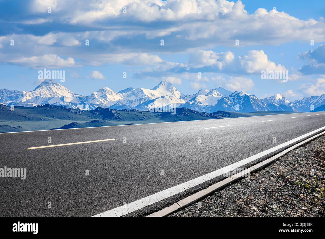 Asphalt road and snow mountain with beautiful sky clouds under blue sky Stock Photo
