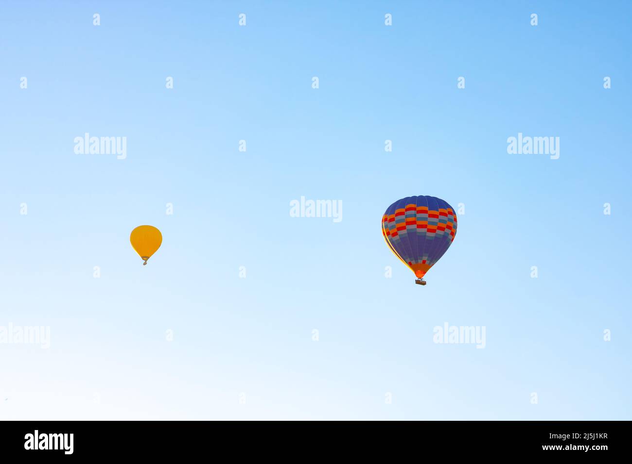 Two hot air balloons on the sky. Ballooning activity background photo. Hot air balloon festival concept. Stock Photo