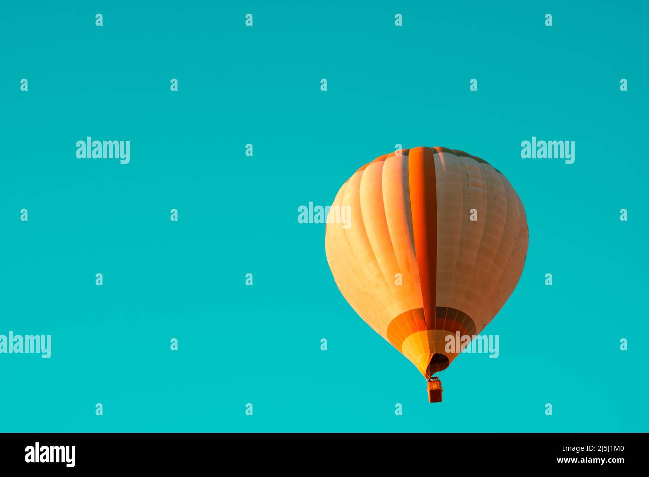 Hot air balloon isolated on turquoise background. Ballooning festival or activity background photo. Stock Photo