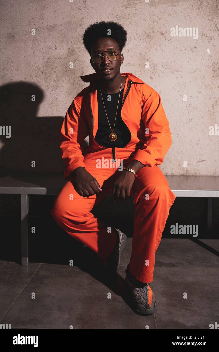 Black prisoner in an orange jumpsuit looking directly to camera Stock
