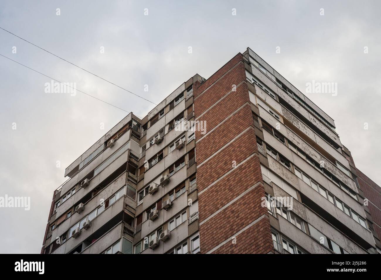 Picture of Eastern European towers in Belgrade, Serbia, in poor condition with concrete falling down and old AC units. These buildings are a symbol of Stock Photo