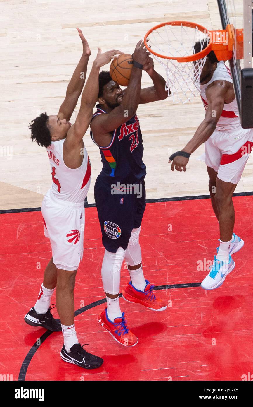 April 23, 2022, Toronto, ON, CAN: Toronto Raptors forward Scottie Barnes,  left, blocks a shot from Philadelphia 76ers' Joel Embiid (21) as Raptors' Thaddeus  Young looks on during first half NBA first