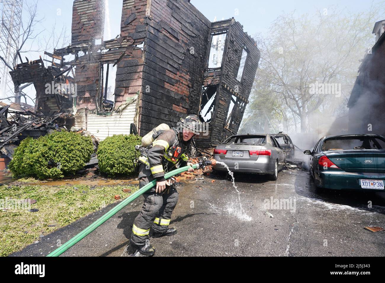 St. Louis, United States. 23rd Apr, 2022. A St. Louis firefighter advances a line into the driveway to put out fires in cars next to two homes that were destroyed by fire in St. Louis on Saturday, April 23, 2022. Strong winds helped push the fire from one home to the next destroying two and seriously damaging another. One firefighter was transported to a local hospital after succumbing to the heat of the fires. Photo by Bill Greenblatt/UPI Credit: UPI/Alamy Live News Stock Photo