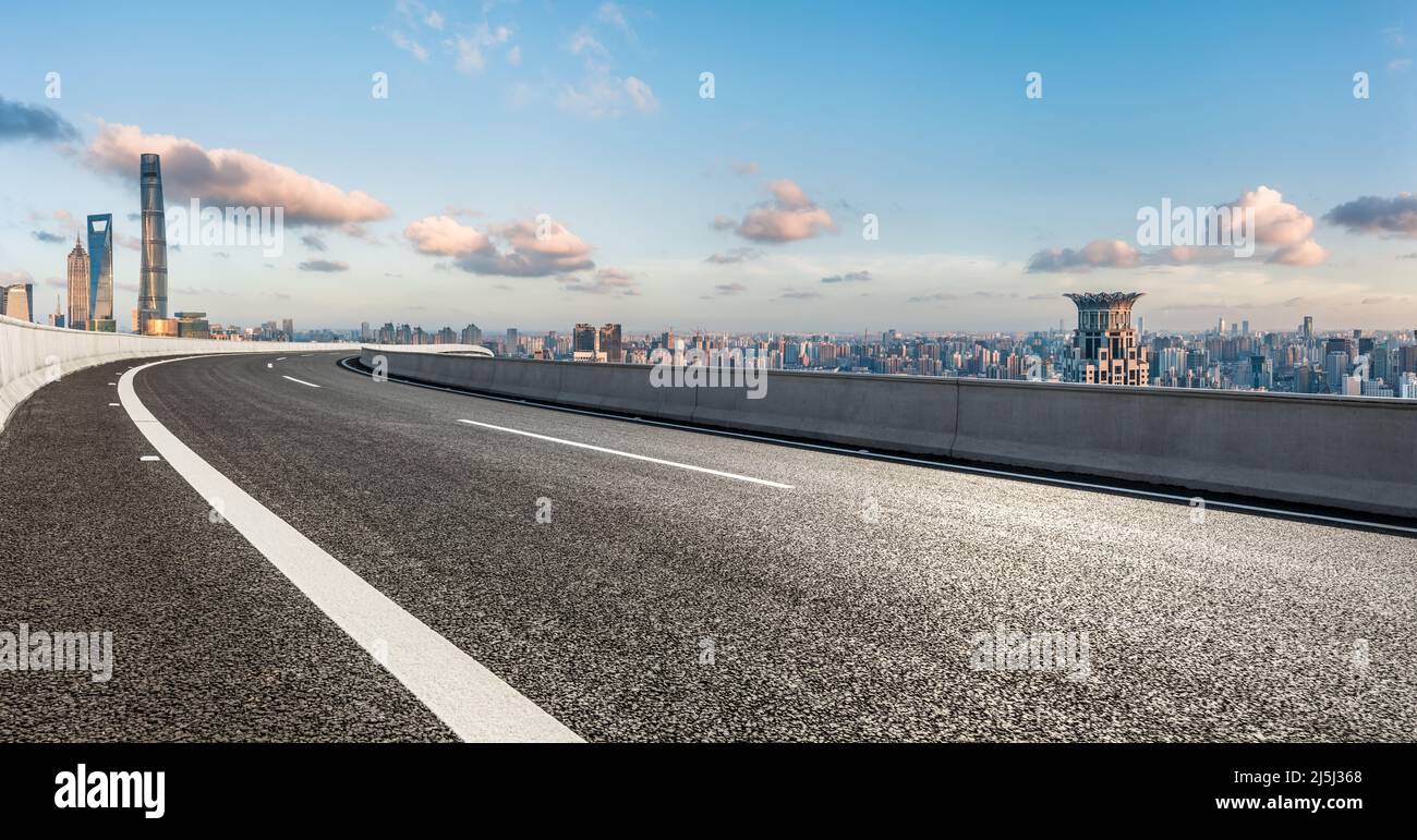 Asphalt highway and city skyline with modern buildings in Shanghai at sunset, China. Stock Photo