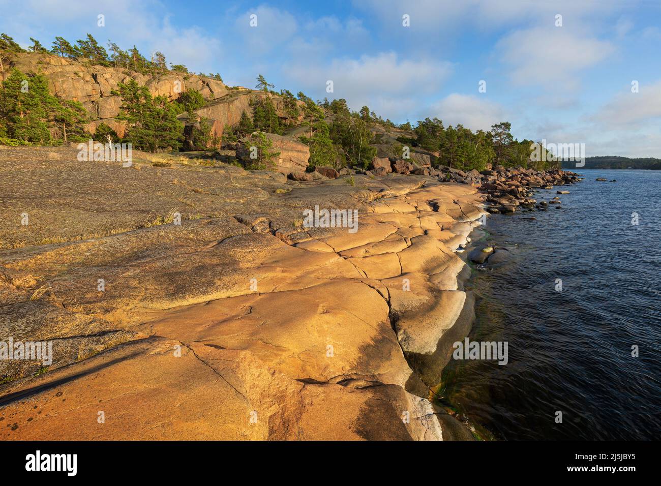 Scenic landscape of a rocky cliff by the sea at Geta in Åland Islands, Finland, on a sunny day in the summer. Off the beaten path in the nature. Stock Photo