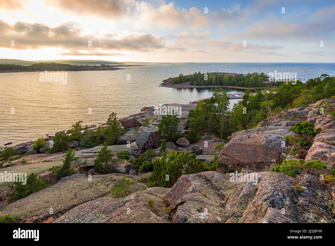 Rocky and forested cliff by the sea at Geta in Åland Islands, Finland, on a sunny day in the summer, viewed from above. Off the beaten path in nature. Stock Photo