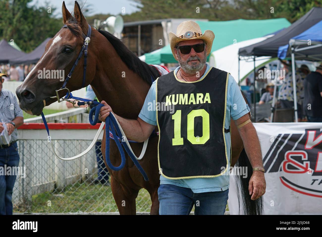 KUMARA, NEW ZEALAND, JANUARY 8, 2022; A trainer warms up his horse before a race at the Gold Nuggets competition at the Kumara Race Track, January 8, Stock Photo