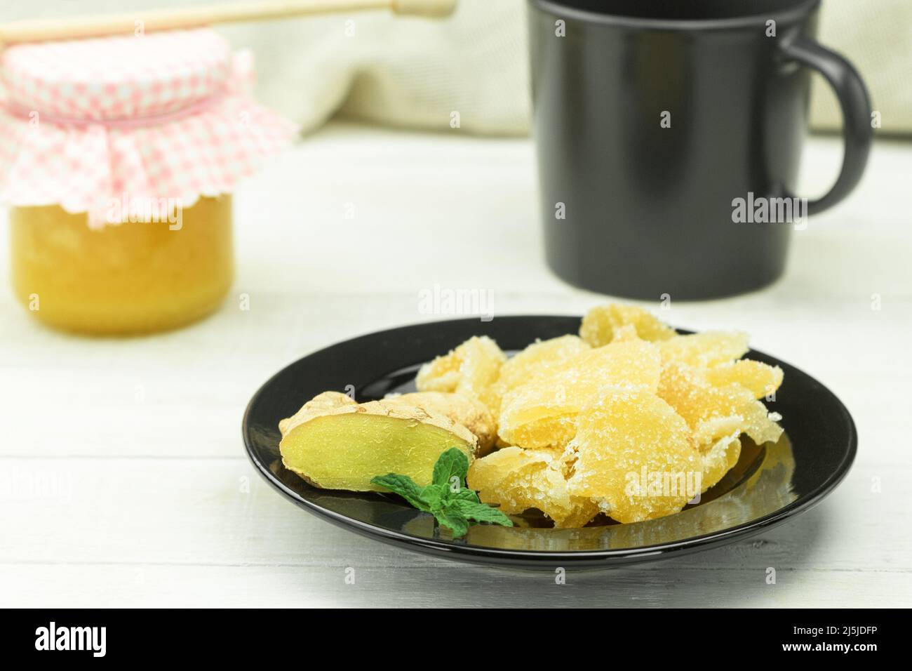Three kinds of ginger ground spice fresh and candied on rustic table